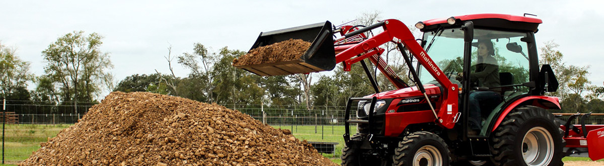 Red 2017 Mahindra 2538-4WD HST tractor picking up dirt.
